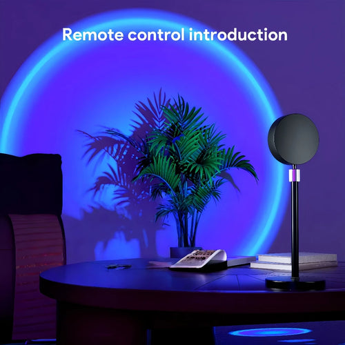 Table with remote control, lamp, and books under a blue circular light projection.